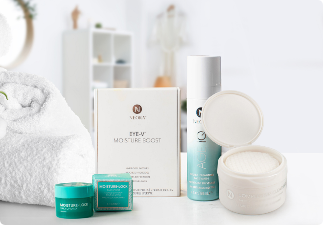 El paquete de cuidado de la piel de Neora, que incluye el limpiador facial de doble Acción Age IQ, las almohadillas para el tratamiento del Acné, los parches Eye-V Hydrogel Moisture Boost y la máscara de labios Moisture-Lock en el mostrador del baño. 